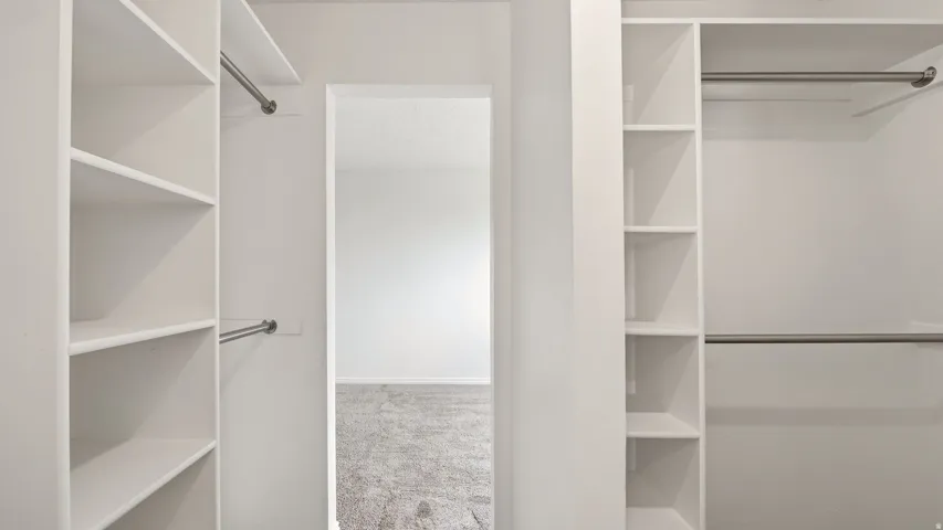 Built-in closet system featuring white shelving and chrome hanging rods