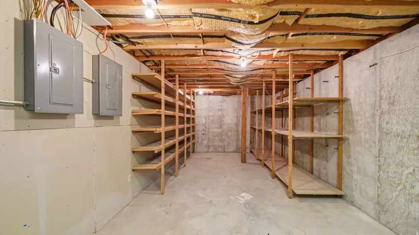 Unfinished basement with concrete flooring and exposed ceiling joists