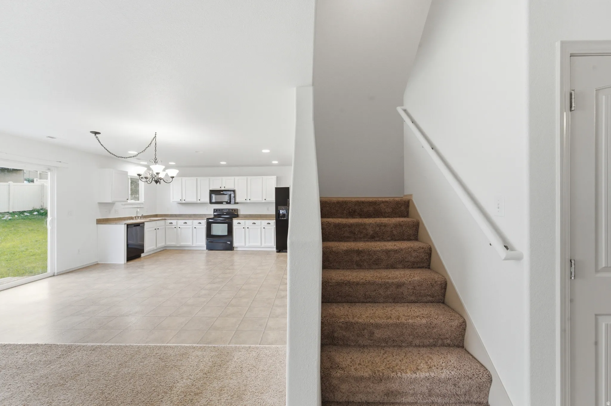 Kitchen featuring white cabinetry and black appliances