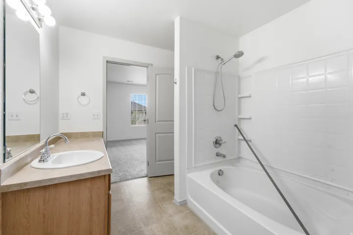 Bathroom featuring a wood-finish vanity with an integrated sink and a cultured marble countertop