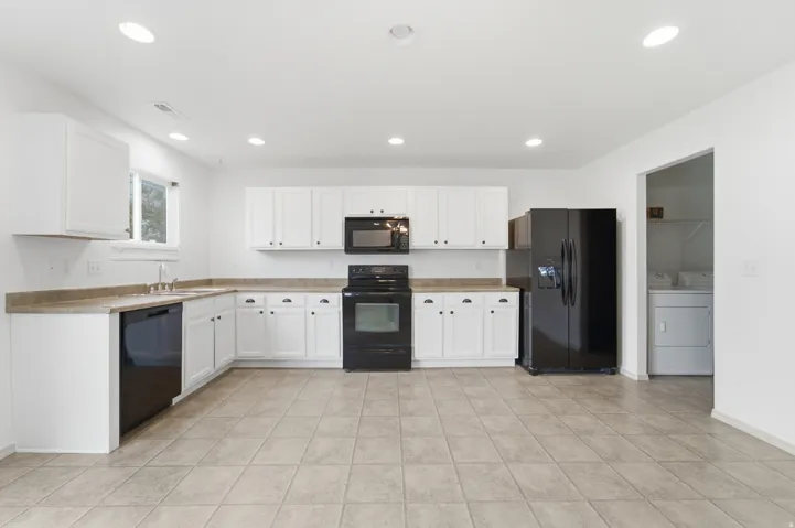 Kitchen featuring white cabinetry, black appliances, recessed lighting, and tile flooring