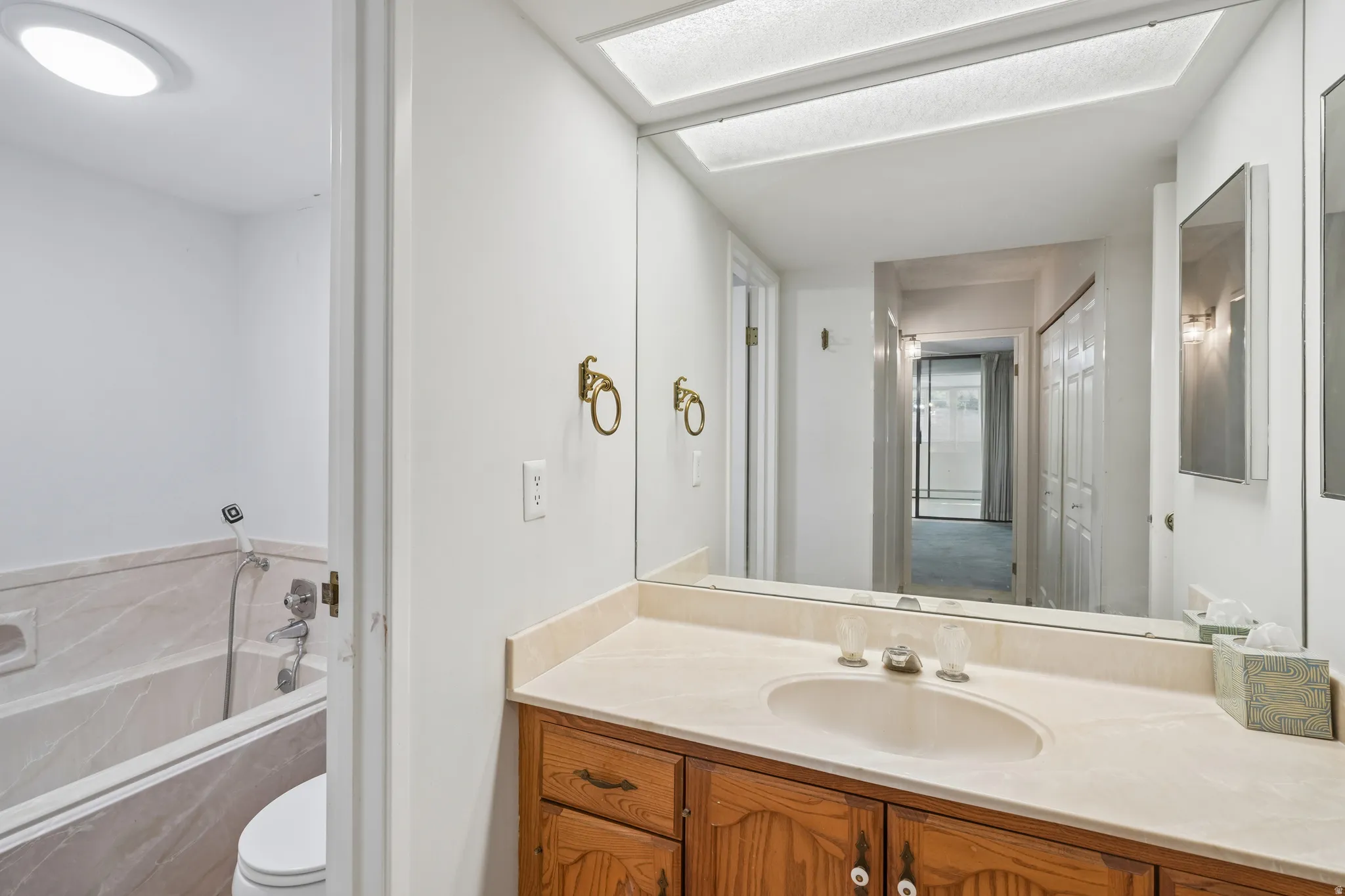 Bathroom vanity featuring a light-toned countertop with integrated sink