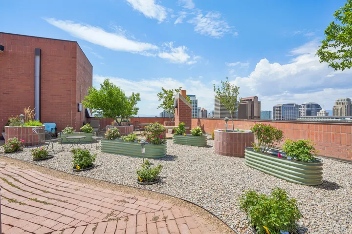Rooftop terrace featuring a brick perimeter wall, extensive gravel surfacing, and a winding brick pathway