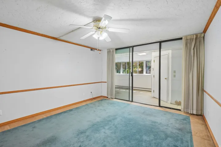 Room featuring light blue carpeting, wood trim detailing, and a ceiling fan