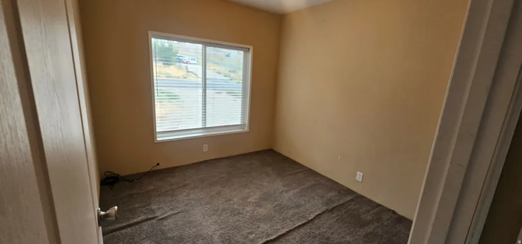 Room featuring neutral wall tones, window with white blinds, and brown carpet flooring