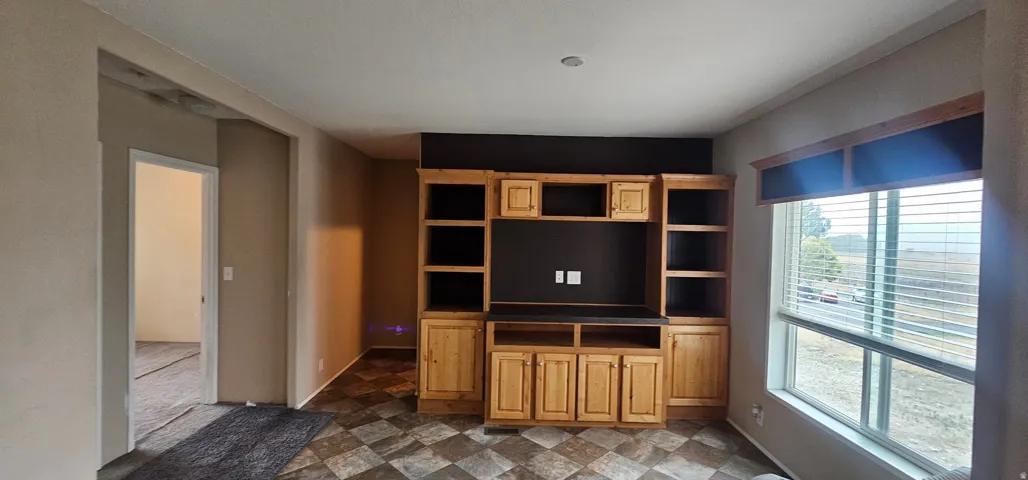 Living area featuring a natural wood-finish entertainment center with integrated shelving and cabinetry