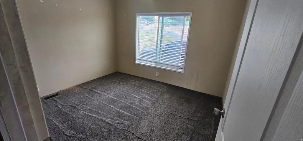 Carpeted room with a double-pane window featuring horizontal blinds