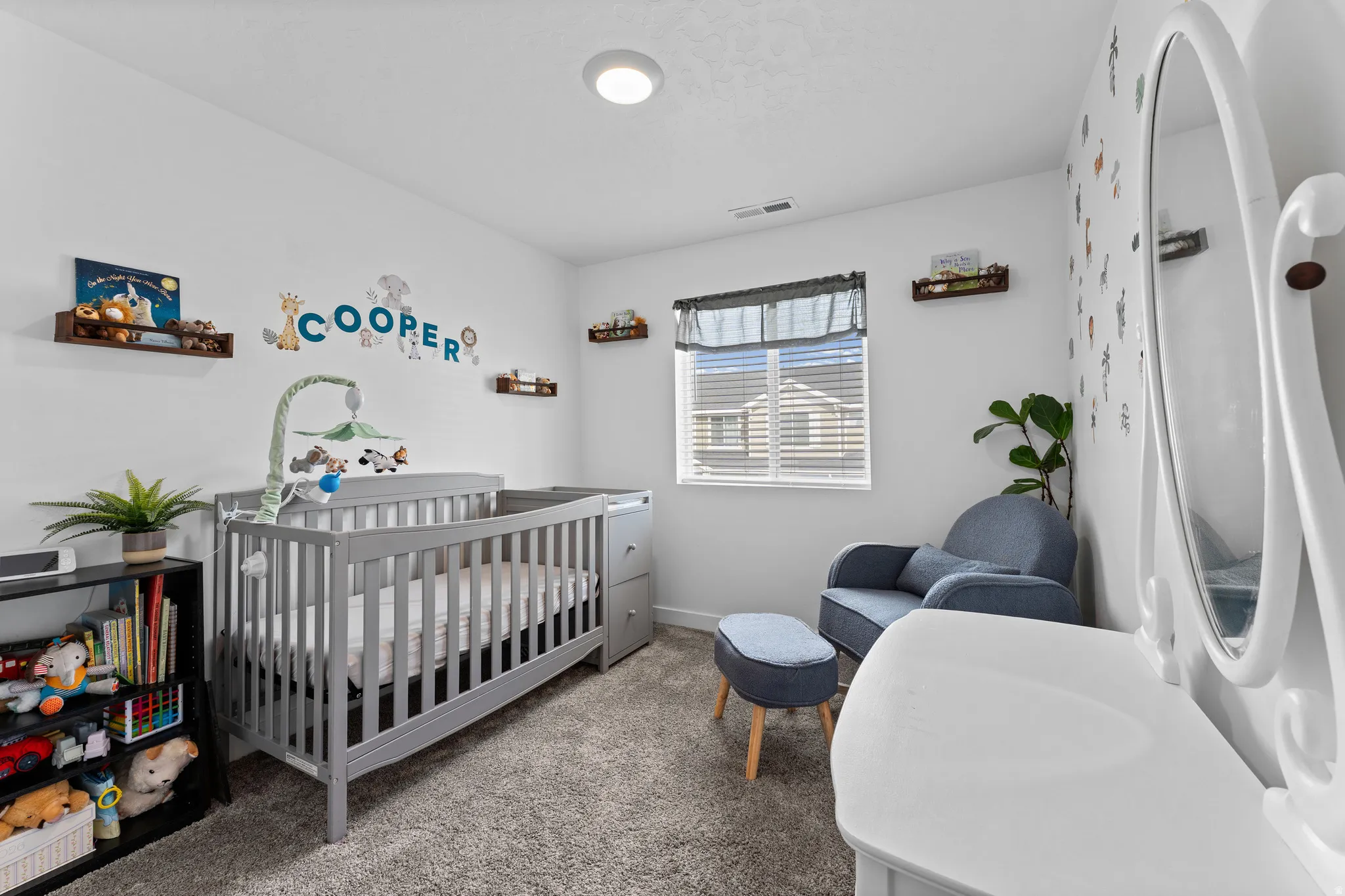 Carpeted room with a ceiling-mounted light fixture, recessed window with blinds, and white painted walls