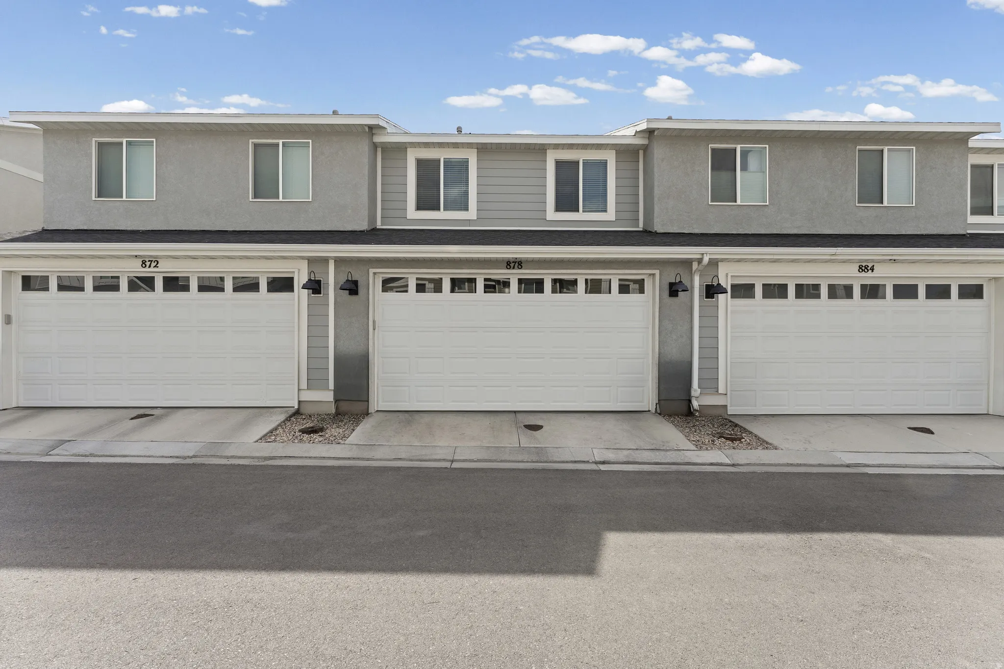 Townhome exterior featuring light gray stucco and siding