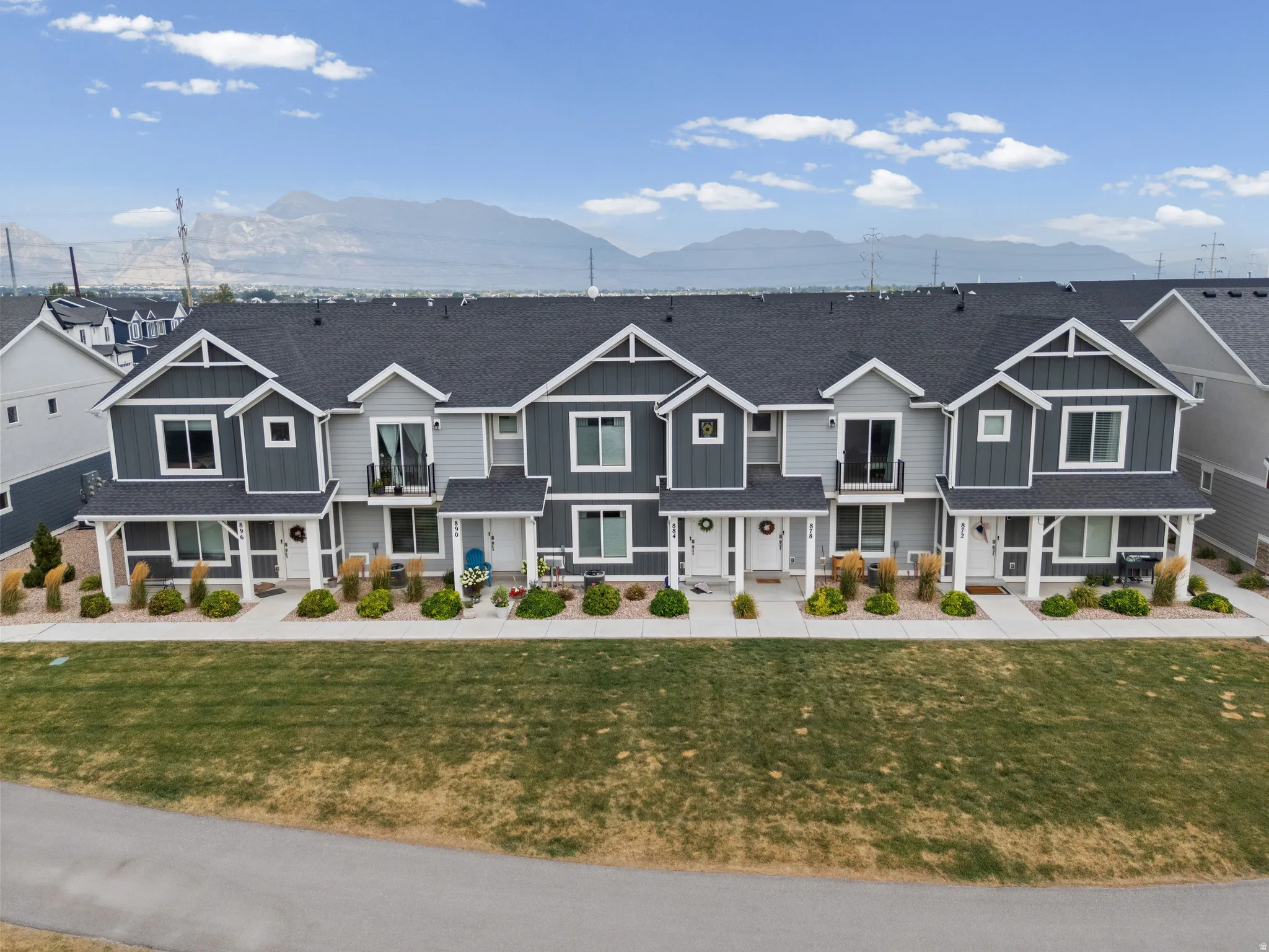Modern townhome row featuring charcoal and light gray siding with white trim accents