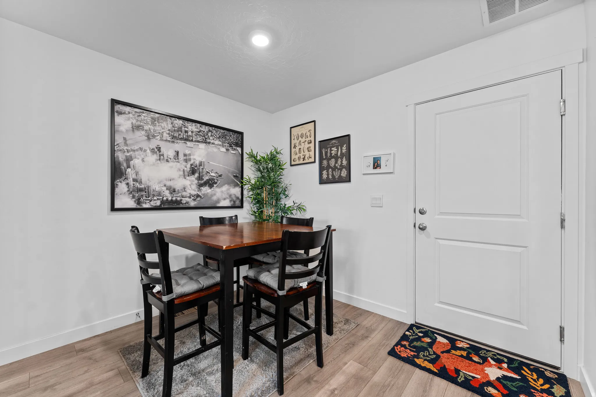 Bright interior space featuring light wood-finish flooring, white baseboards, and a two-panel interior door