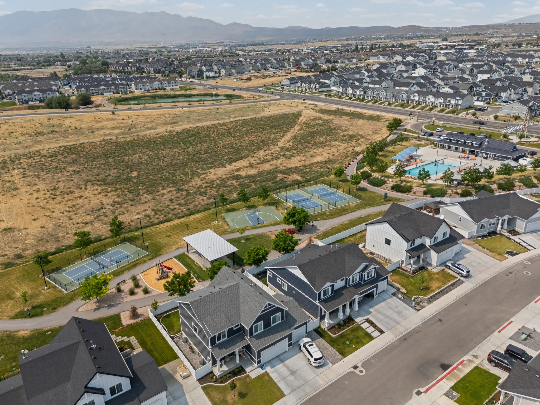 Aerial perspective showcasing residential properties within a community featuring multiple recreational amenities