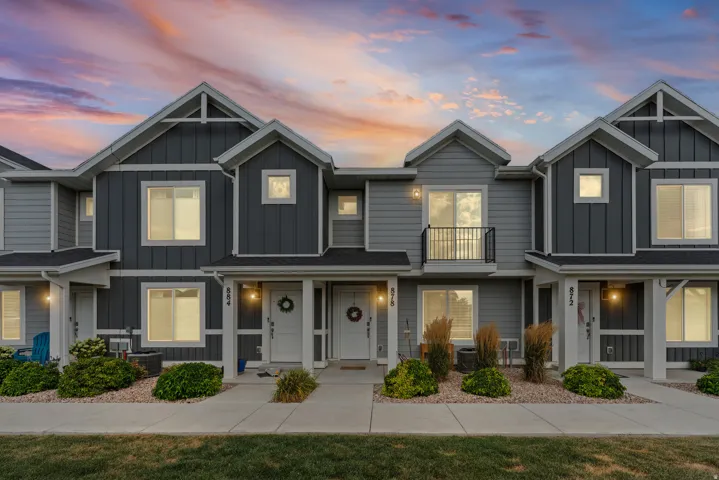 Modern townhome exteriors featuring horizontal and vertical siding, white trim accents, and individual entryways