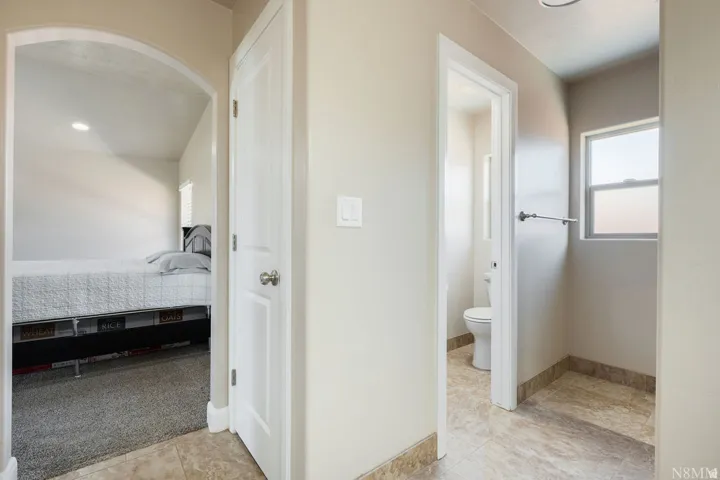 Hallway with neutral wall tones and tile flooring