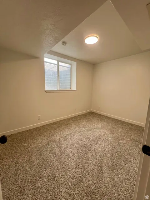 Room featuring neutral-toned carpet, white painted walls, and a recessed window