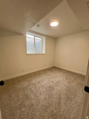 Room featuring neutral-toned carpet, white painted walls, and a recessed window