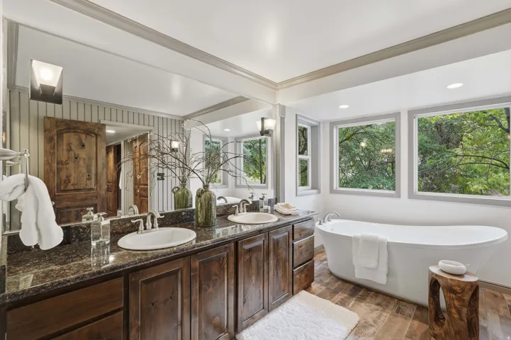 Primary bathroom featuring a freestanding soaking tub and dual vanity with integrated sinks