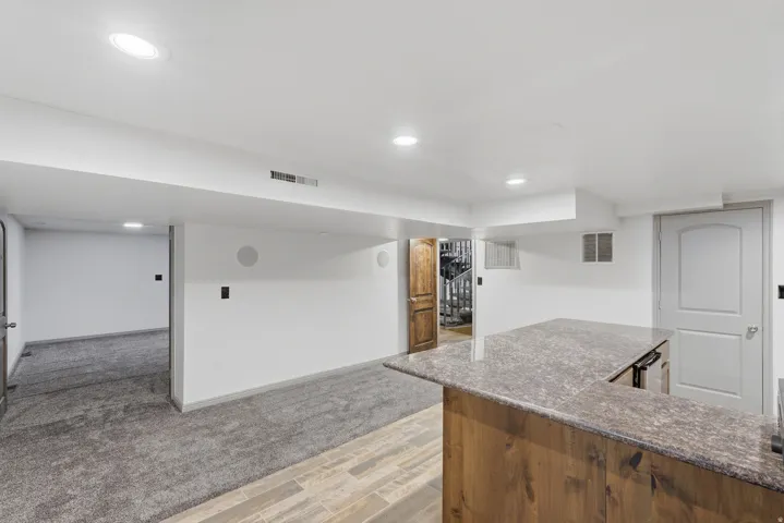Entertainment area featuring a built-in bar with granite countertop, and integrated beverage refrigerator