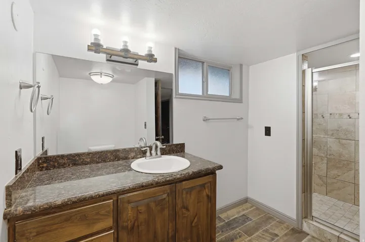 Bathroom featuring a single-sink vanity with a dark wood-finish cabinet and a speckled countertop