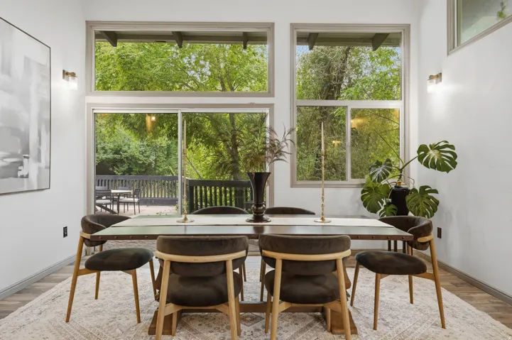 Dining area featuring oversized windows and a sliding glass door leading to the outdoor fire pit and patio area.