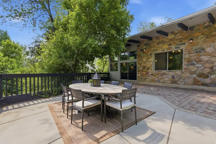 Expansive outdoor patio featuring a combination of concrete slab and brick pavers