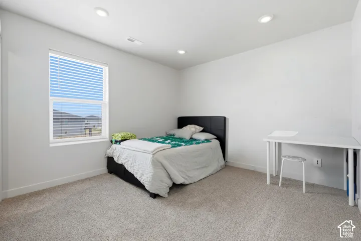 Bedroom featuring neutral carpeting and white walls