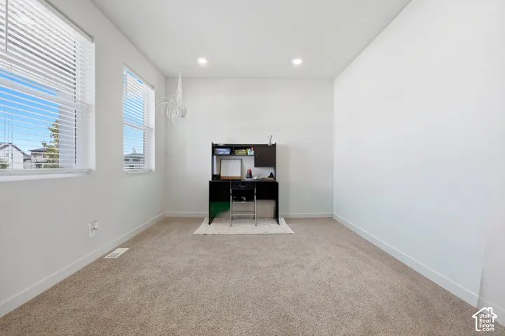 Bright interior space with two windows featuring horizontal blinds