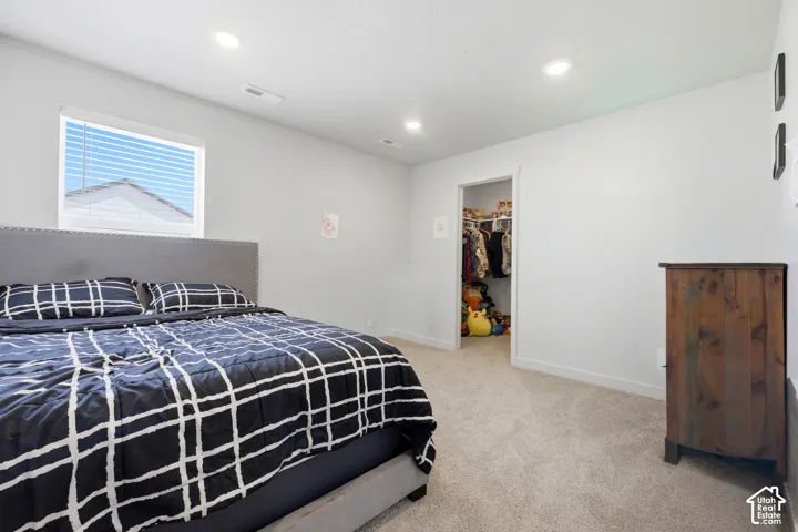 Carpeted bedroom with a single window featuring horizontal blinds