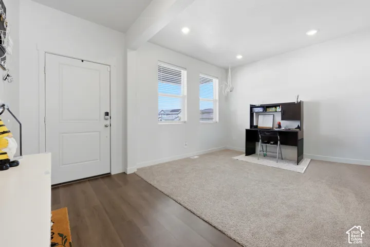 Entryway featuring wood-finish flooring, a white paneled door, and recessed lighting