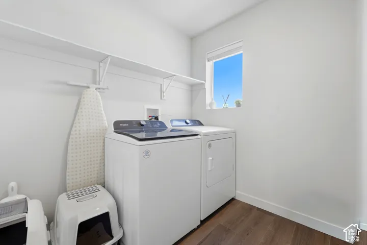 Dedicated laundry area featuring a window, wood-finish flooring, and integrated wall shelving