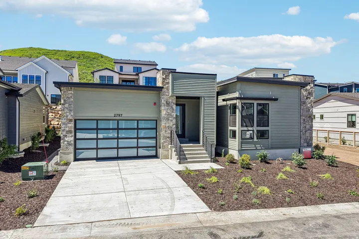 Contemporary exterior featuring varied siding, stone accents, and a flat roofline