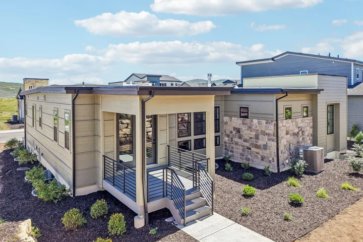 Contemporary exterior featuring horizontal siding, stone veneer accents, and a flat roofline
