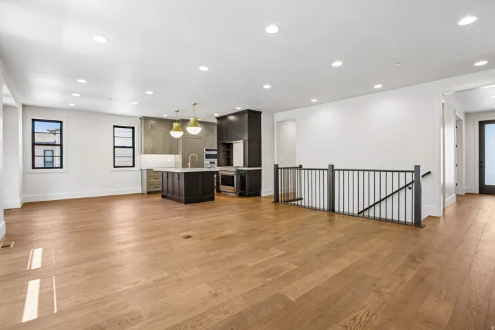 Open-concept living space featuring wood-finish flooring, recessed lighting, and a contemporary kitchen