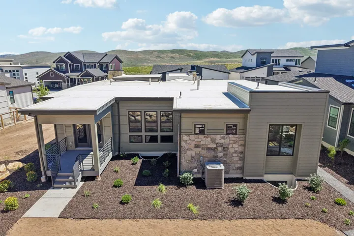 Contemporary exterior featuring horizontal siding in a neutral tone, stone accents, and a flat roofline