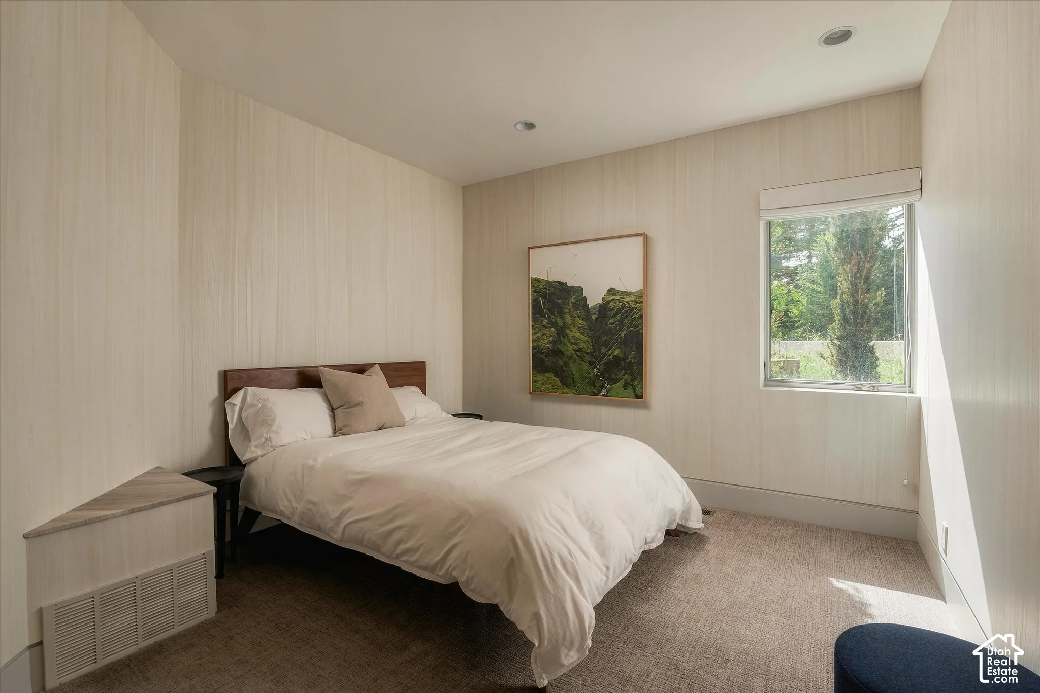 Textured wall coverings, recessed ceiling lighting, a window with a roller shade, and wall-to-wall carpeting