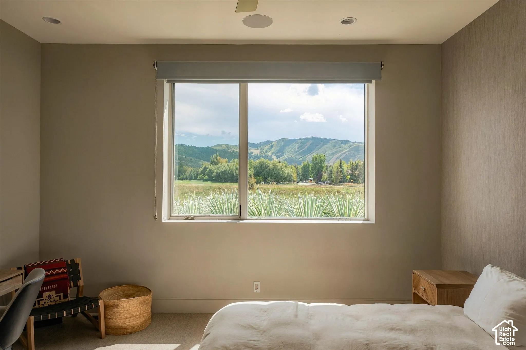 Large window with roller shade, recessed ceiling lighting, and a ceiling fan