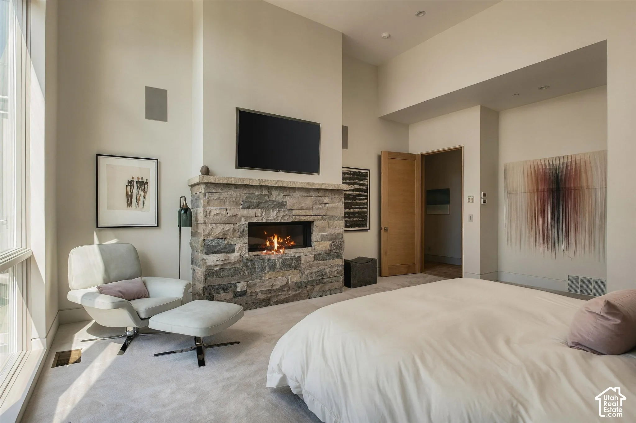 Stone-clad fireplace with an integrated linear firebox, natural wood door, and large windows