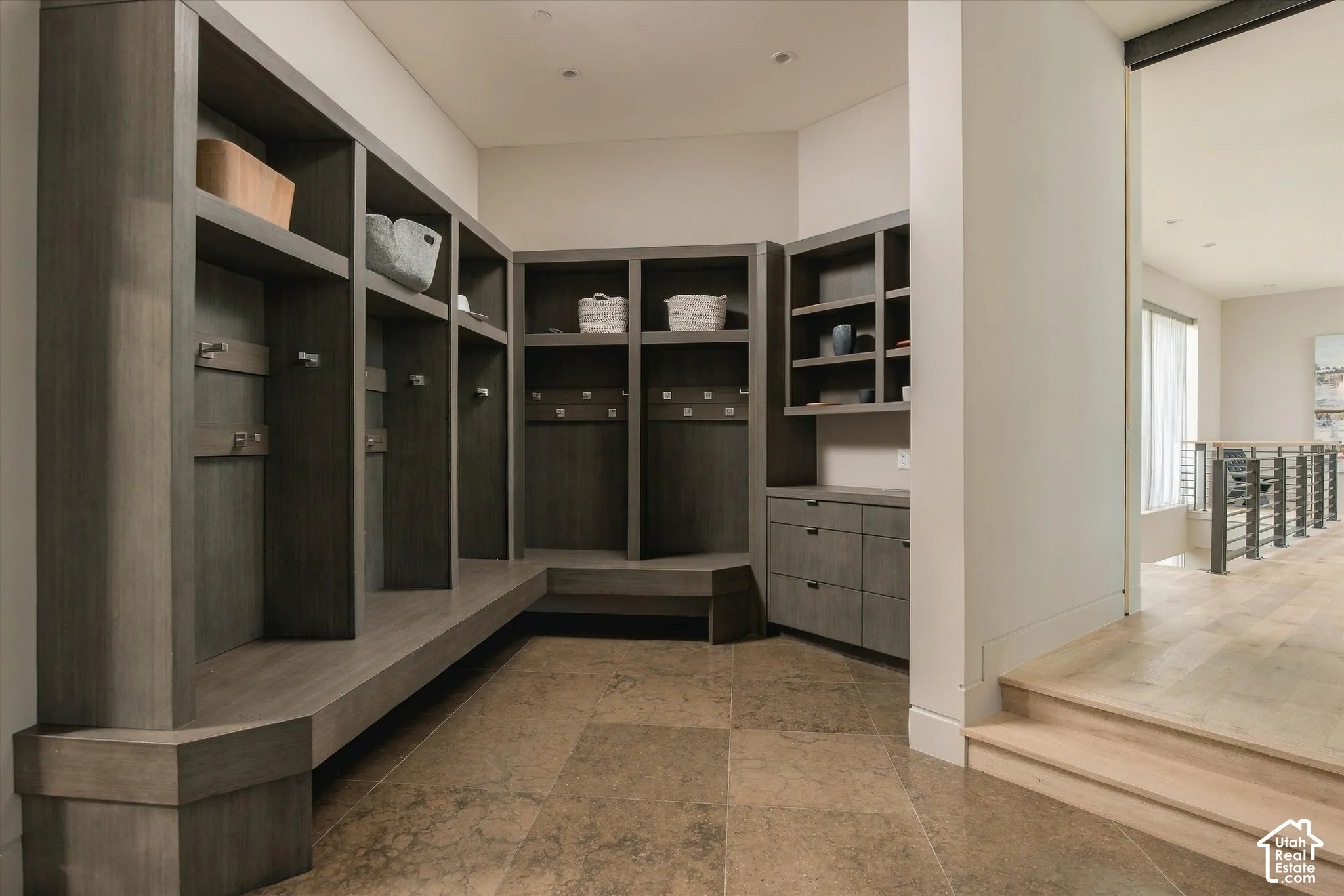 Built-in wood-finish cabinetry, integrated seating, and large-format floor tiling