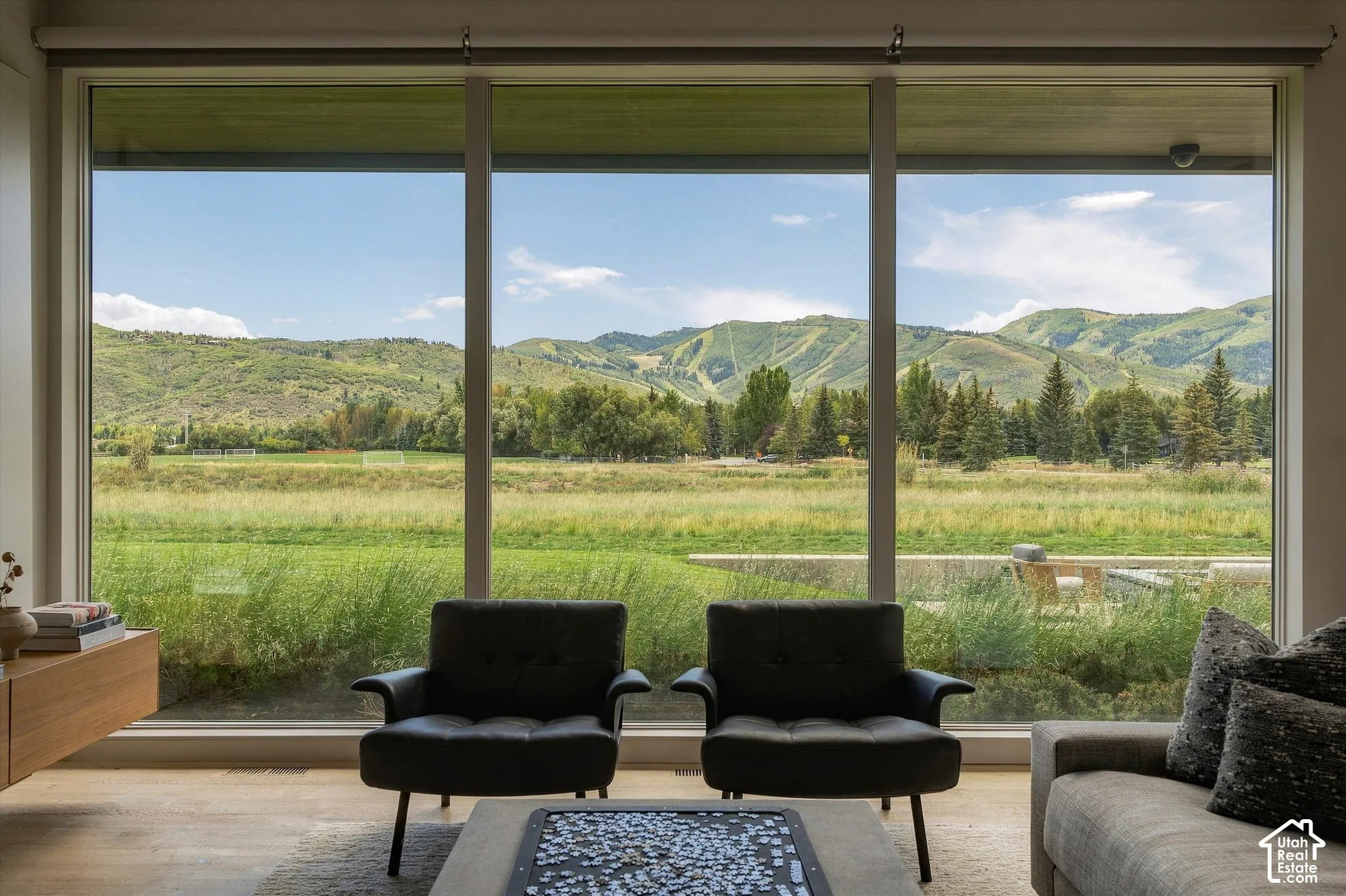 Expansive window wall with mountain and field scenery