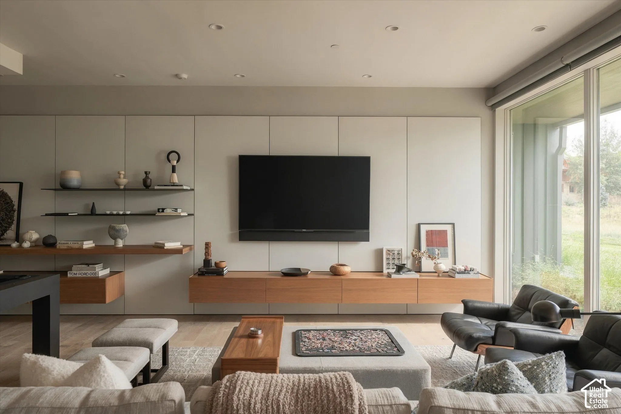 Built-in media wall with integrated storage, wood-finish console, and recessed lighting