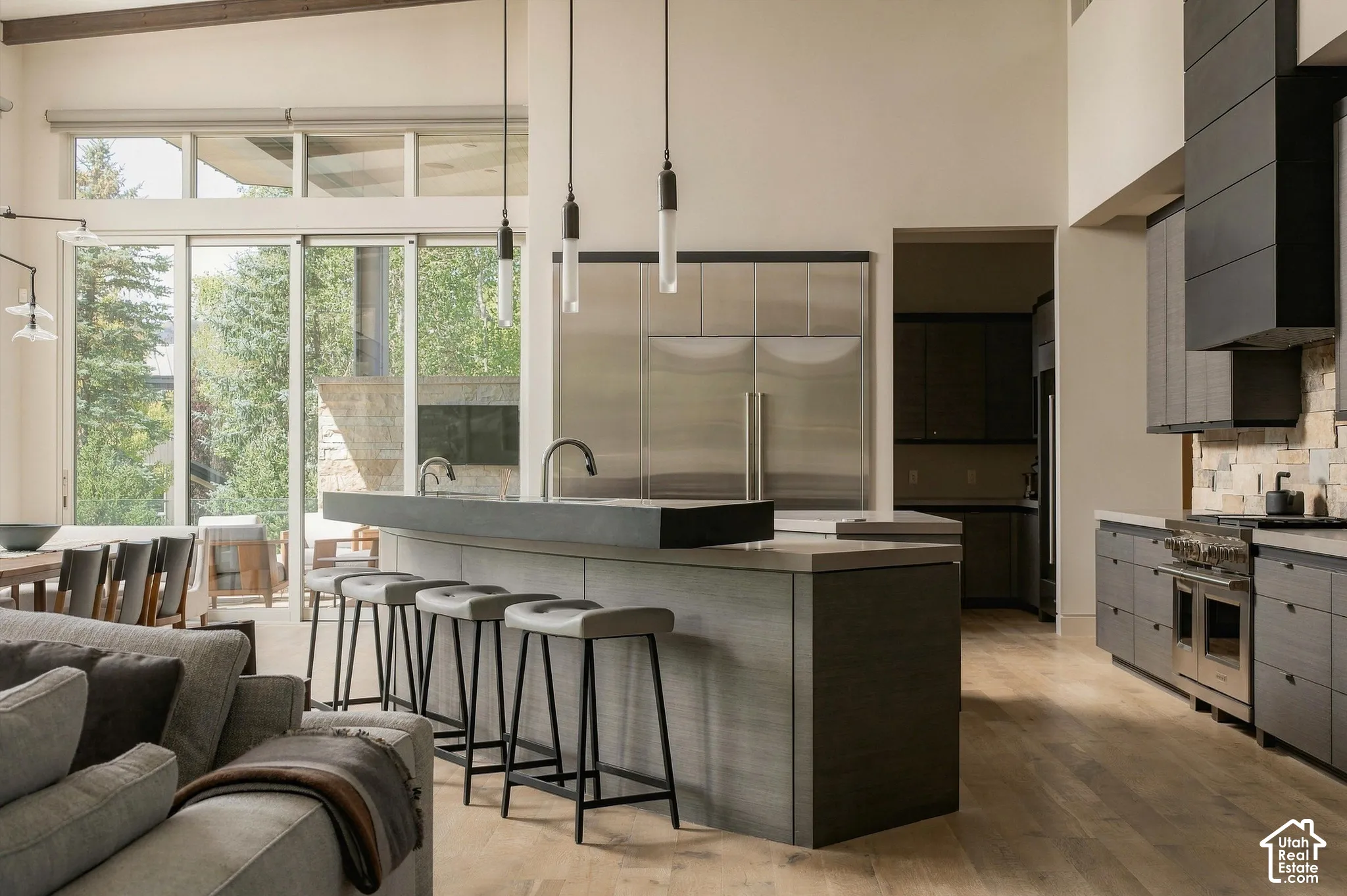 Expansive kitchen featuring a large island with seating, stainless steel appliances, and wood-finish flooring