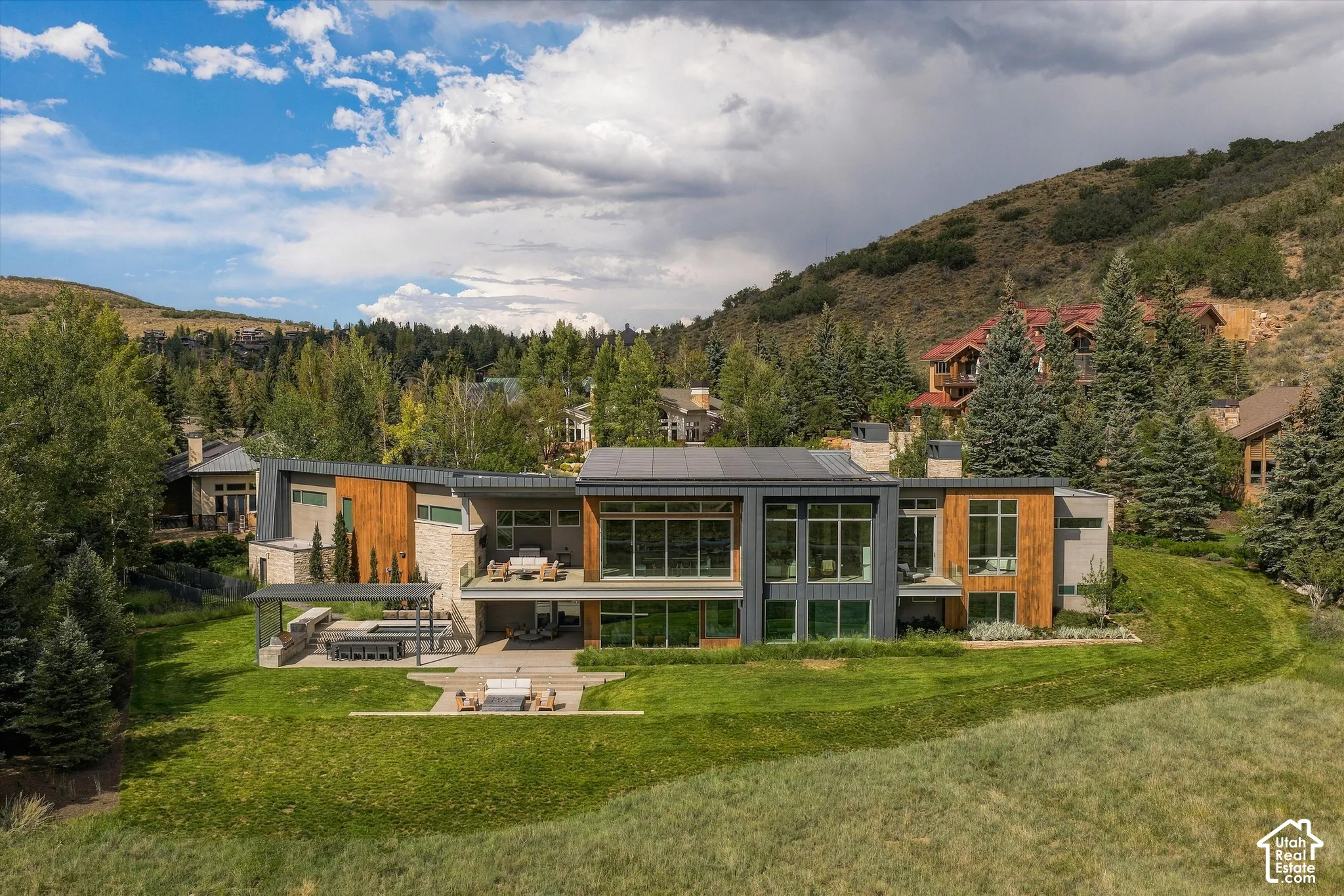 Contemporary architecture featuring extensive glazing, stone, and wood paneling