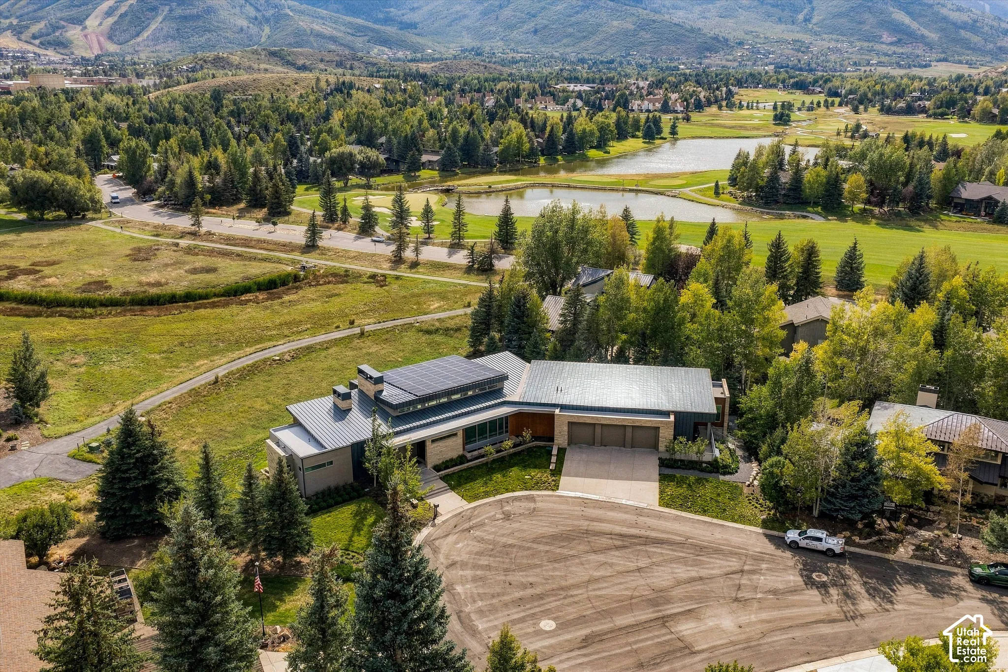 Modern exterior with solar panels, a multi-car garage, and a manicured lawn
