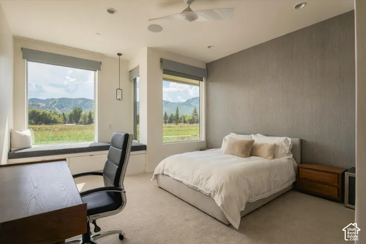 Wall-to-wall carpeting with large windows, a built-in window seat, a ceiling fan, and recessed lighting