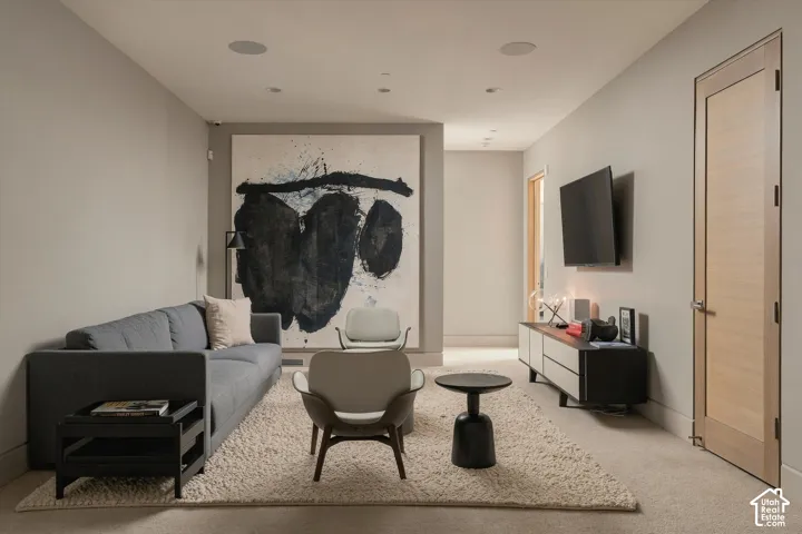 Recessed ceiling lighting, wood-paneled door, and neutral-toned walls