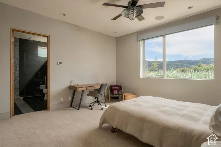 Recessed lighting, ceiling fan, expansive window with mountain scenery, wood-framed doorway, and plush carpeting