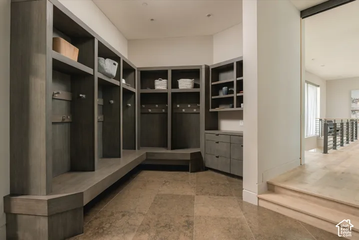 Built-in wood-finish cabinetry, integrated seating, and large-format floor tiling