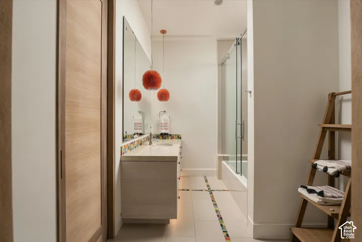 Floating vanity with light-toned cabinetry, a built-in sink, and a full-width mirror