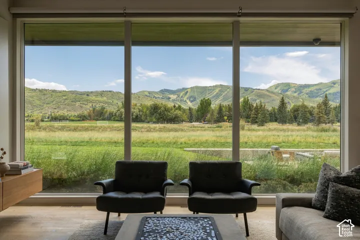 Expansive window wall with mountain and field scenery