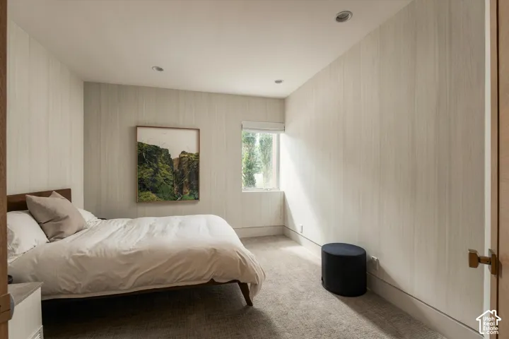 Recessed ceiling lighting, textured wall coverings, carpeted flooring, and a single window